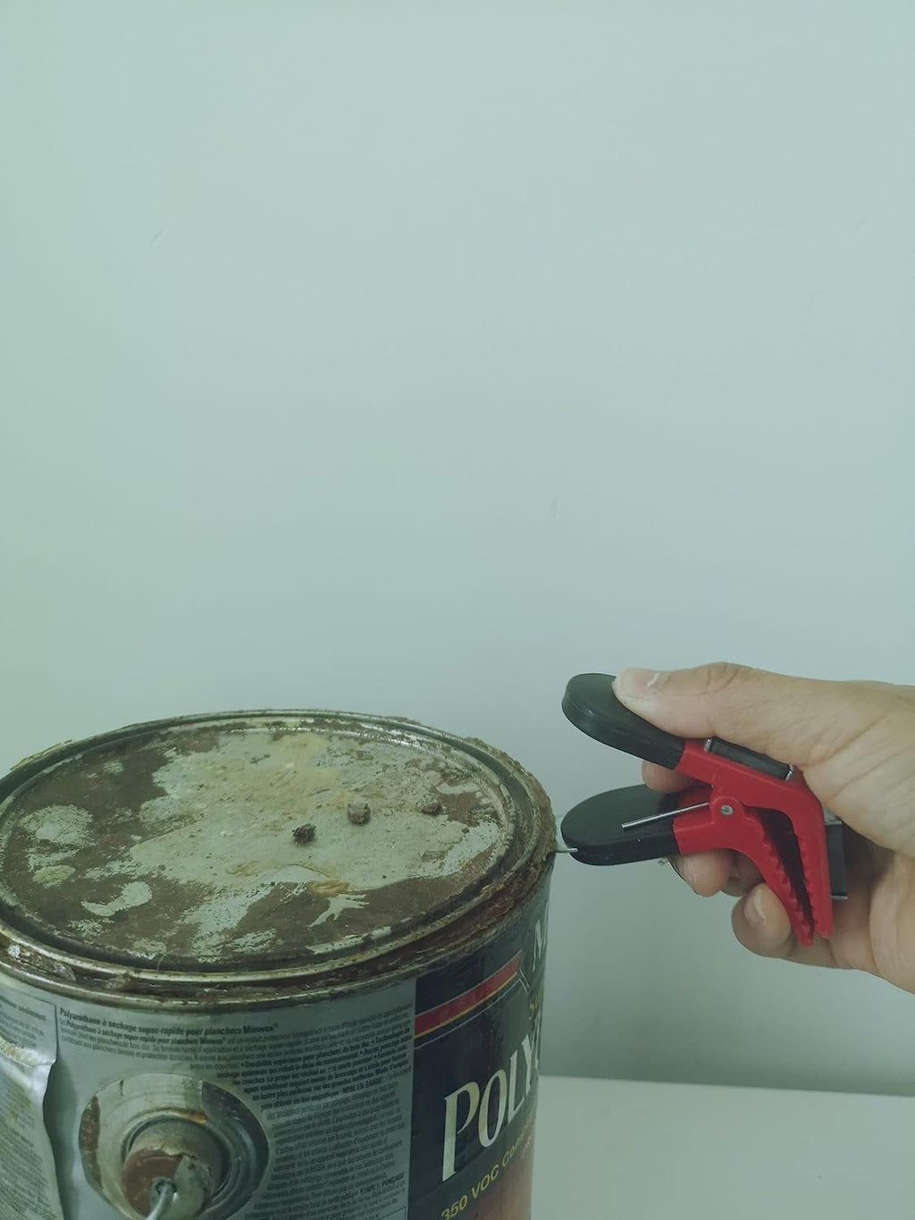 Paint can opener in hand